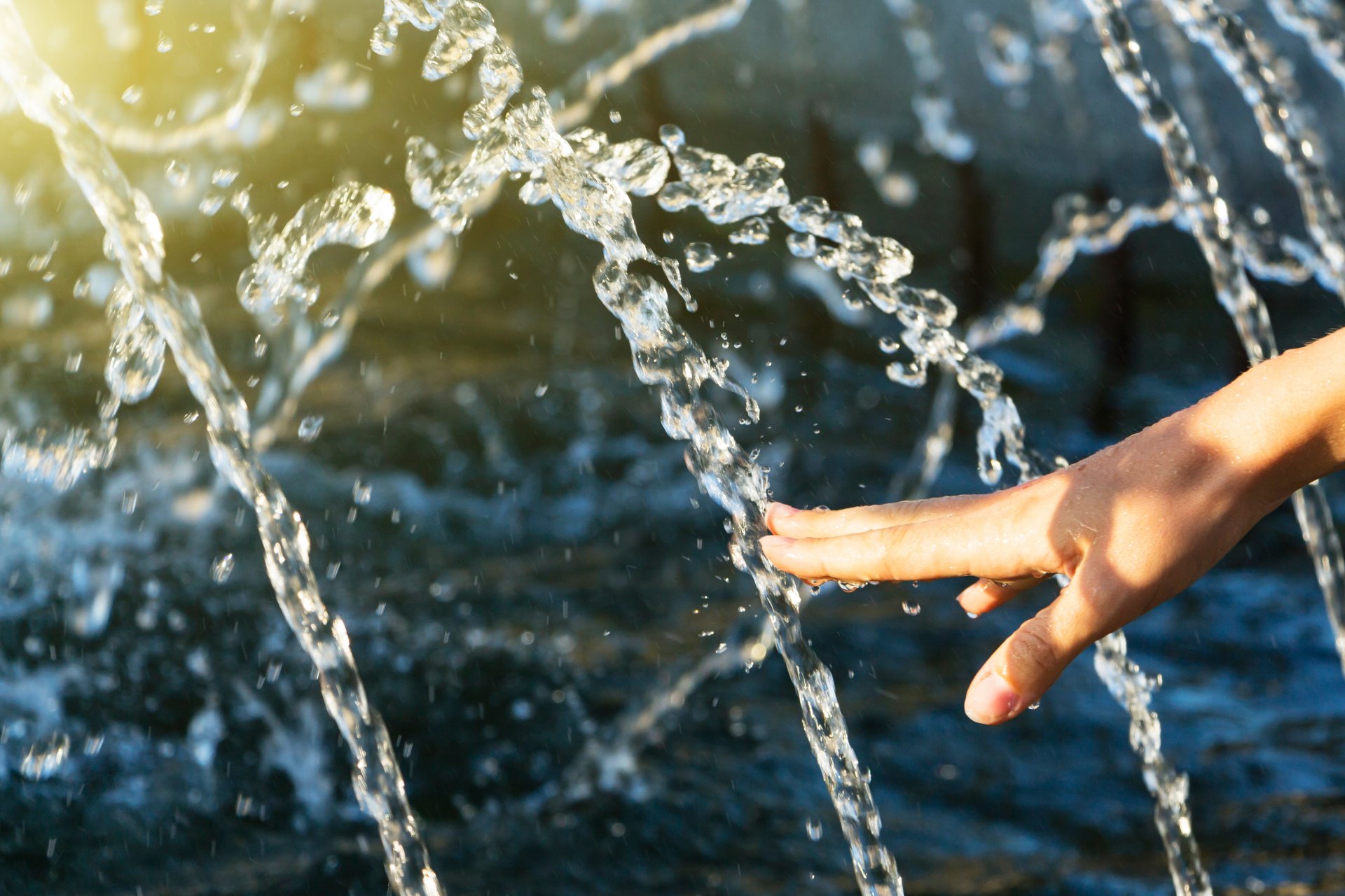 main touchant une fontaine